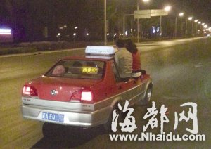 沈阳一对男女坐在疾驰出租车窗上玩自拍