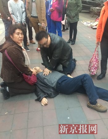 医生救助路边晕倒老人。新京报记者 左燕燕 摄