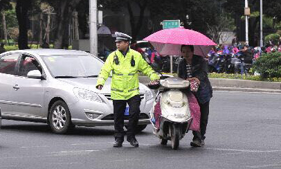 一名男子骑装有遮阳伞的超标电动车，还闯红灯，被处320元罚款