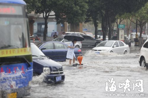 小施见到险情，赶紧蹚水赶过去，把一把橙色的伞插在井盖上，提醒过往车辆绕行