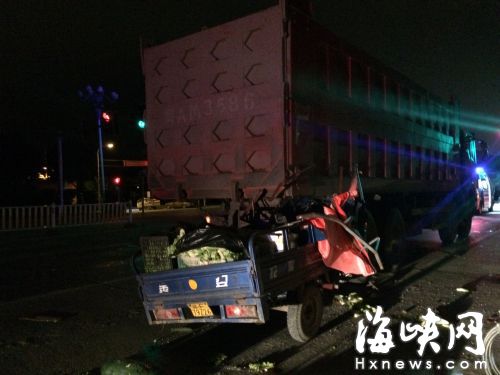 运菜的电动三轮车，车头卡在货车后