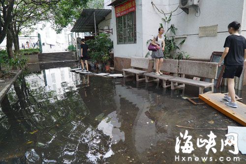福州北浪路冠军楼前成“洪涝区” 居民搭桥进出
