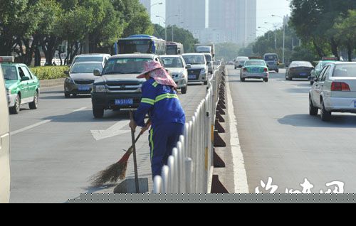 环卫工在马路中央清扫垃圾，非常危险