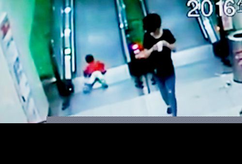 小孩摔在电梯踏板上(视频截图)