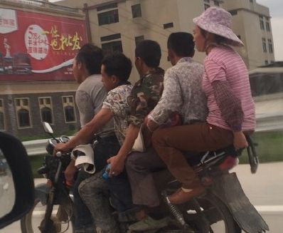 摩托车载5人均未戴头盔 一路飞驰时速约50公里