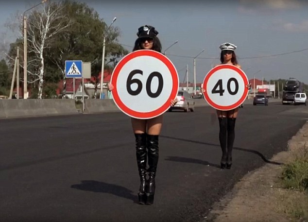 太惊奇！俄女子赤裸上身公路上举牌提醒车辆慢行