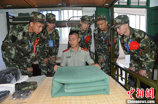 刚入营的新兵观摩学习班长叠被子。 苏高龙　摄