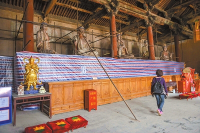游客来到正在修复中的下寺后佛殿参观。