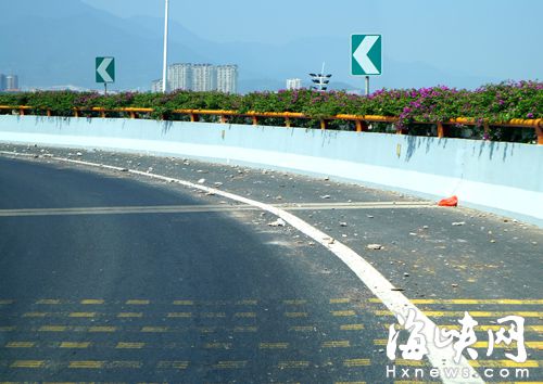 福州西三环弯道路面上满是碎石 过往车辆很危险