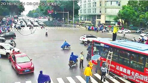 福新路口线缆垂地拦路 交警勇当“托举哥”