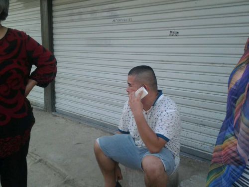 哥哥廖先生坐在地上，拨打电话打听小燕的下落