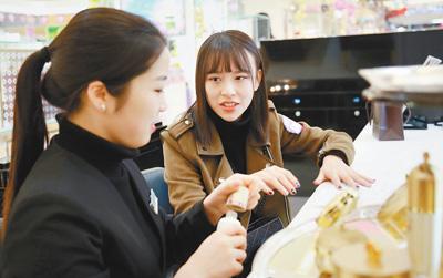 在湖北武汉武昌中南路某商场，一位消费者(图右)正向导购员咨询美妆产品。