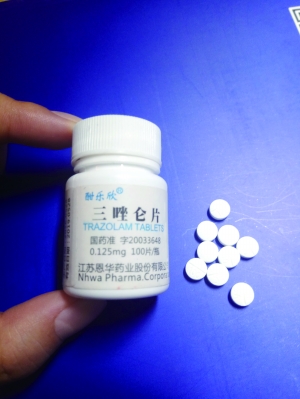 小图为记者收到的药品无外包装，白色小瓶子上写着“三唑仑片”，里面白色药片上却有VC字样。