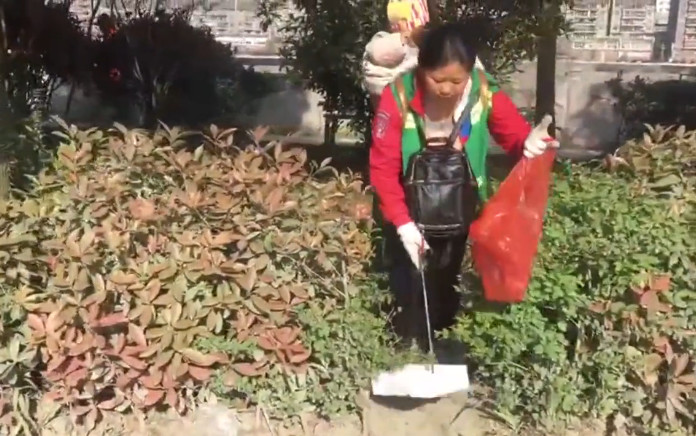 贵州沿河县一环卫工背1岁女儿捡垃圾 当街喂奶(图)