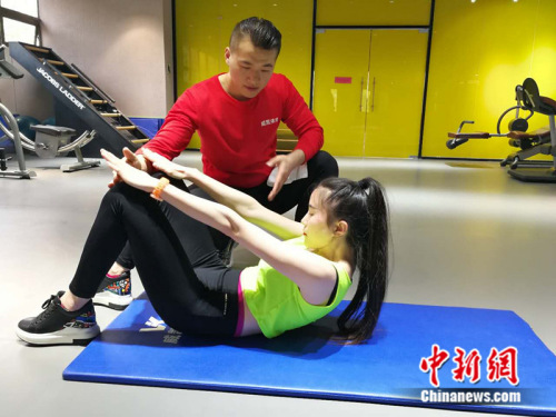 健身教练在健身房指导学员 中新网记者 张尼 摄