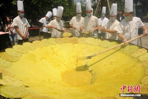 巨无霸煎蛋亮相广州 一群厨师手持1.8米的大铁铲煎蛋