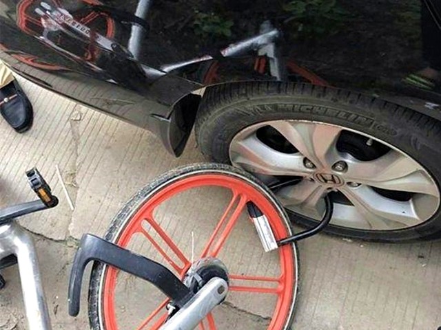 轿车后轮被锁上共享单车 渣人勒索400元
