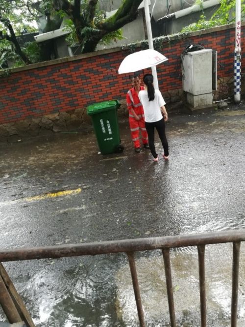 雨中过路女孩为环卫工打伞 被众网友点赞