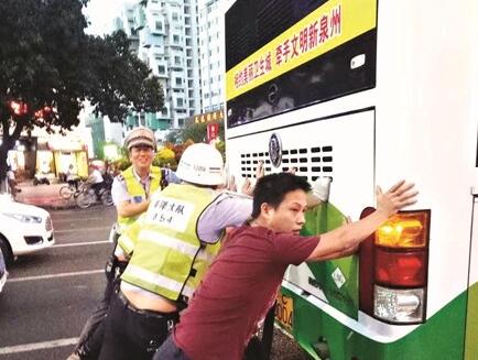泉州市区一公交车雨中抛锚 警民合力推车500米疏堵