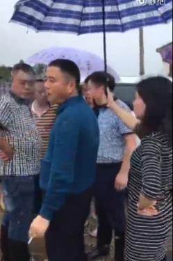 官员救灾时抽烟嚼槟榔女子帮撑伞 被严重警告