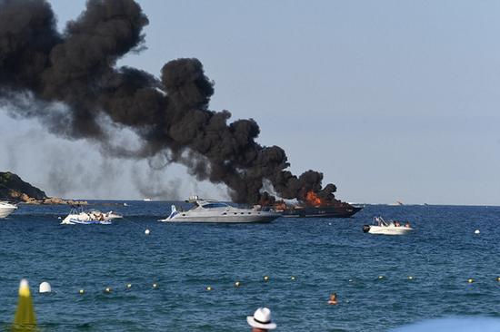 法国一豪华游艇突起大火 浓烟滚滚游客坐海滩淡定围观