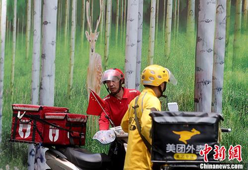 资料图：北京西单街头的外卖骑手准备送餐。 <a target='_blank' href='http://www.chinanews.com/'>中新社</a>记者 张宇 摄