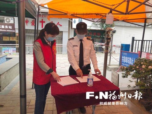 任沐芳（左）向社区保安了解出入人员情况。记者 吴晖 摄