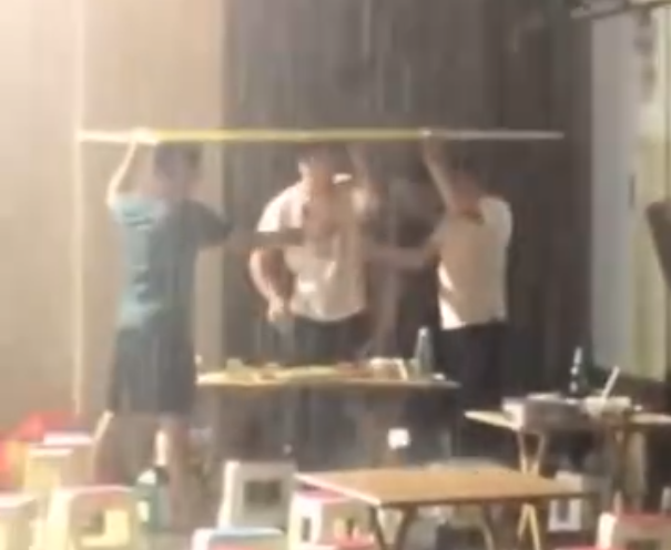 4名男子暴雨中顶纸板喝酒2小时现场图真相揭秘太疯狂了
